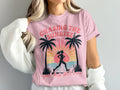 Pink t-shirt with graphic of runner and palm trees at sunrise.