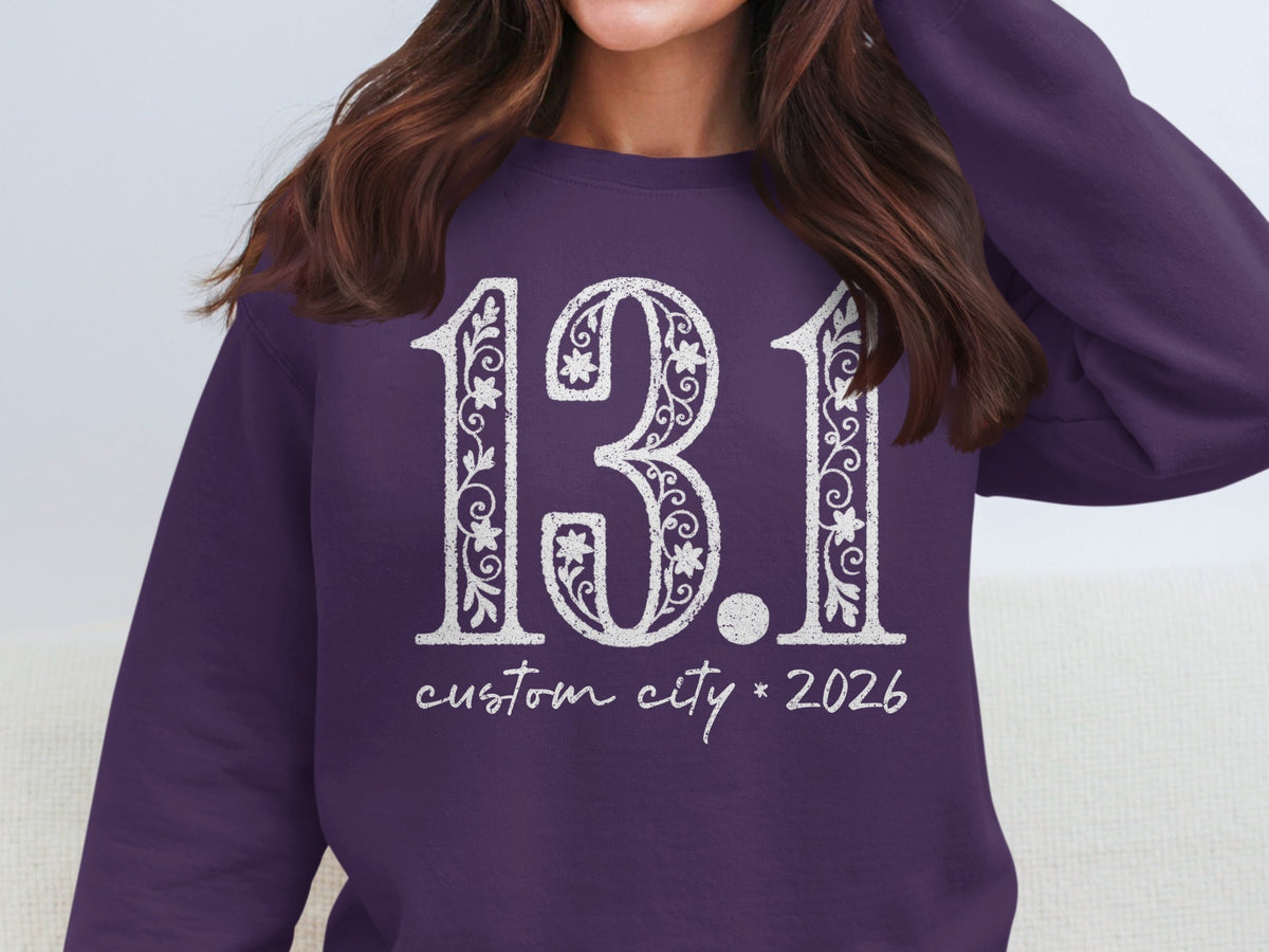 Purple sweatshirt with "13.1 custom city * 2026" in white distressed font.