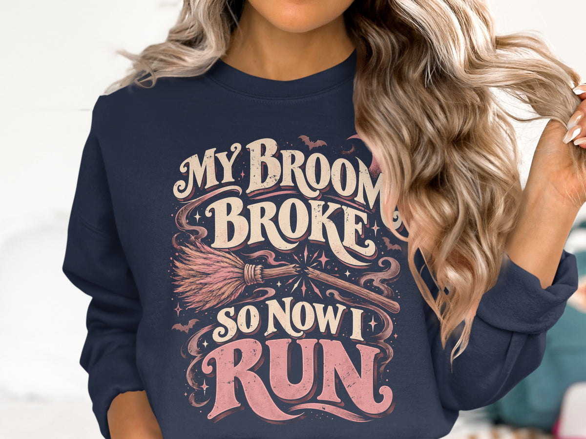 Dark navy sweatshirt with "My broom broke so now I run" text and Halloween graphics.
