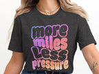 Dark grey t-shirt with "more miles less pressure" in gradient bubble letters.