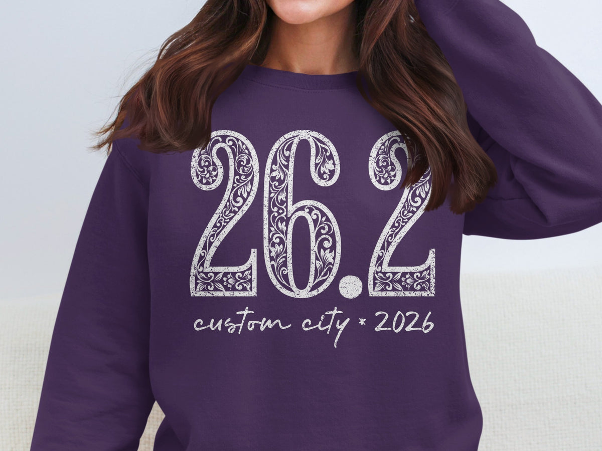 Purple sweatshirt with "26.2 custom city 2026" in distressed white lettering.