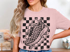 Pink t-shirt with checkered graphic, running shoe, and text.