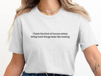 White t-shirt with black text: "i have the kind of trauma where doing hard things feels like healing."